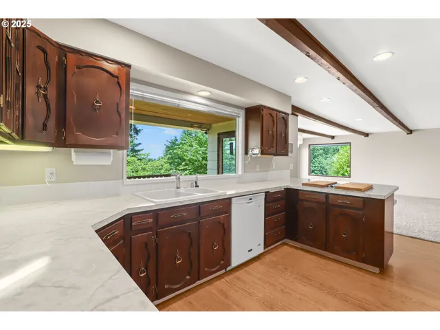 a kitchen with a sink window and cabinets