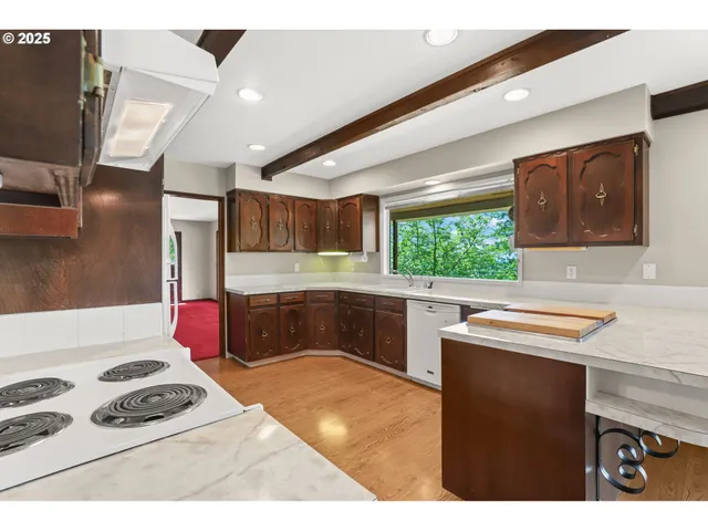 a kitchen with stainless steel appliances kitchen island granite countertop a sink stove and cabinets