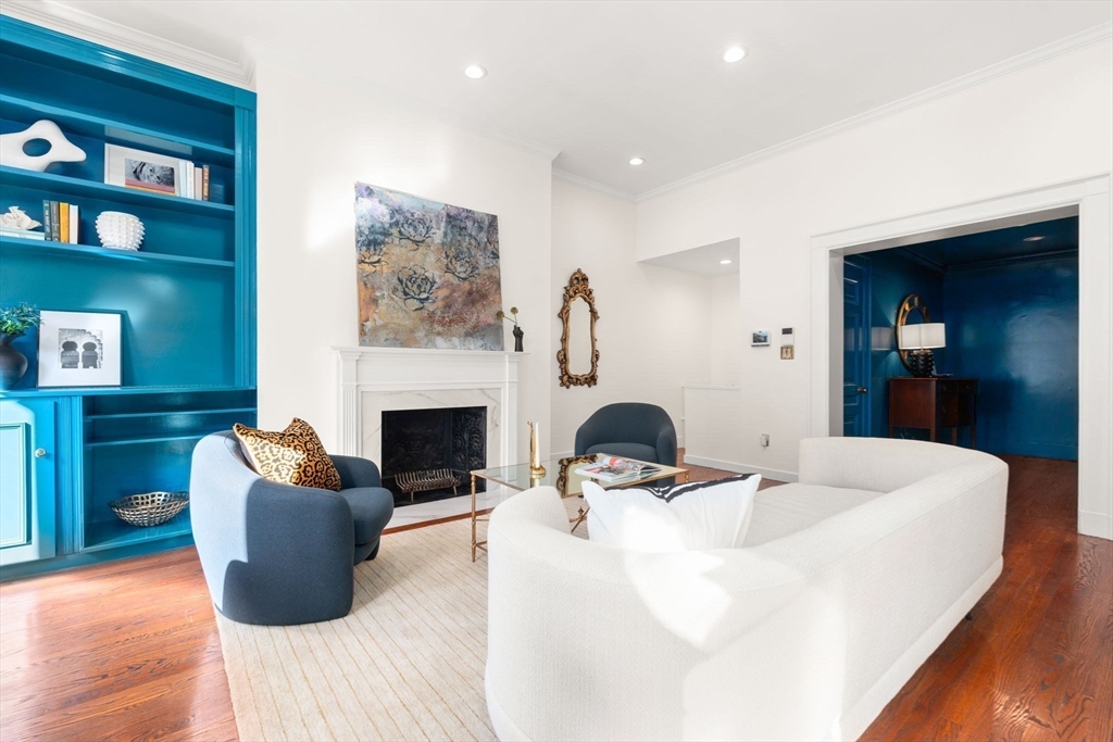 a living room with furniture a fireplace and a wooden floor