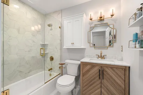 a bathroom with a sink a toilet and shower