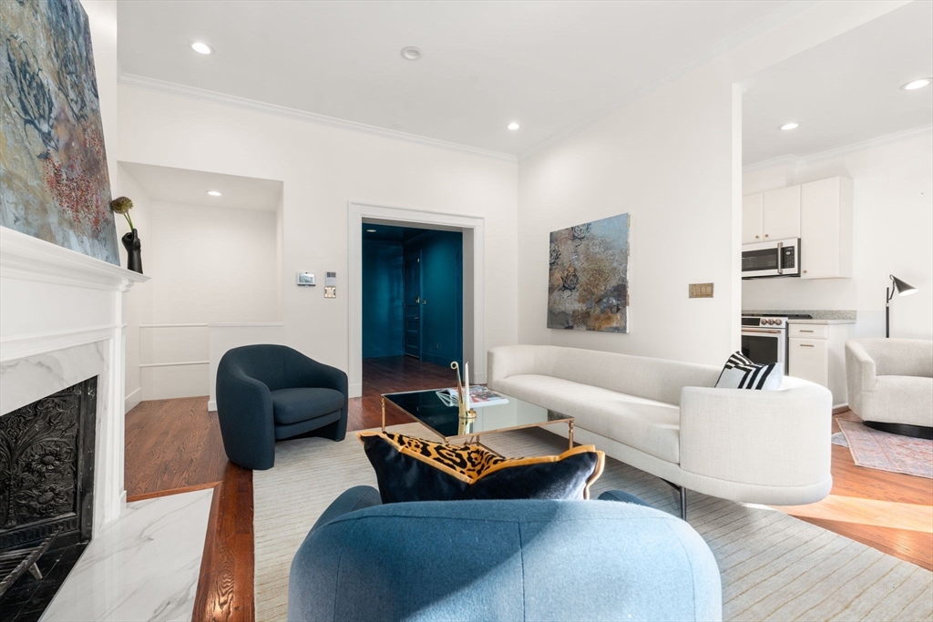 457 Beacon Street, Unit 5 Boston, MA 02115 - Photo 7 of 22 a living room with furniture a fireplace and a flat screen tv