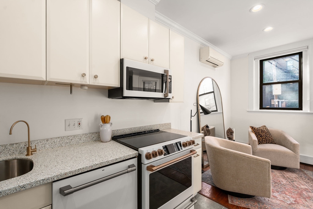 457 Beacon Street, Unit 5 Boston, MA 02115 - Photo 10 of 22 a kitchen with stainless steel appliances granite countertop a sink a stove and a microwave