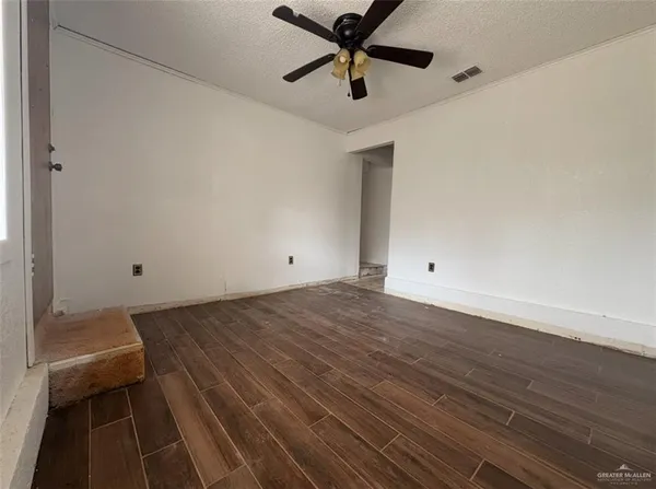 a view of a room with wooden floor and appliances
