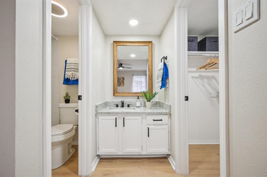 18333 Roehampton Drive, Unit 128 Dallas, TX 75252 - Photo 11 of 40 a bathroom with a granite countertop sink a toilet and a mirror