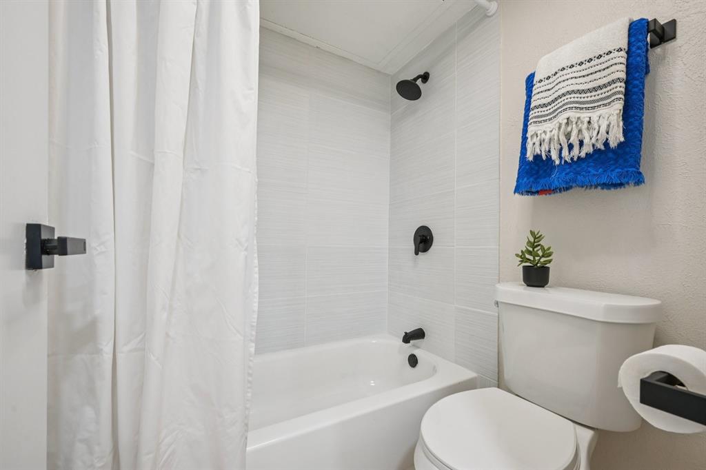 18333 Roehampton Drive, Unit 128 Dallas, TX 75252 - Photo 12 of 40 a white toilet sitting next to a bath tub