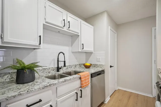 a kitchen with stainless steel appliances granite countertop a sink a stove and cabinets