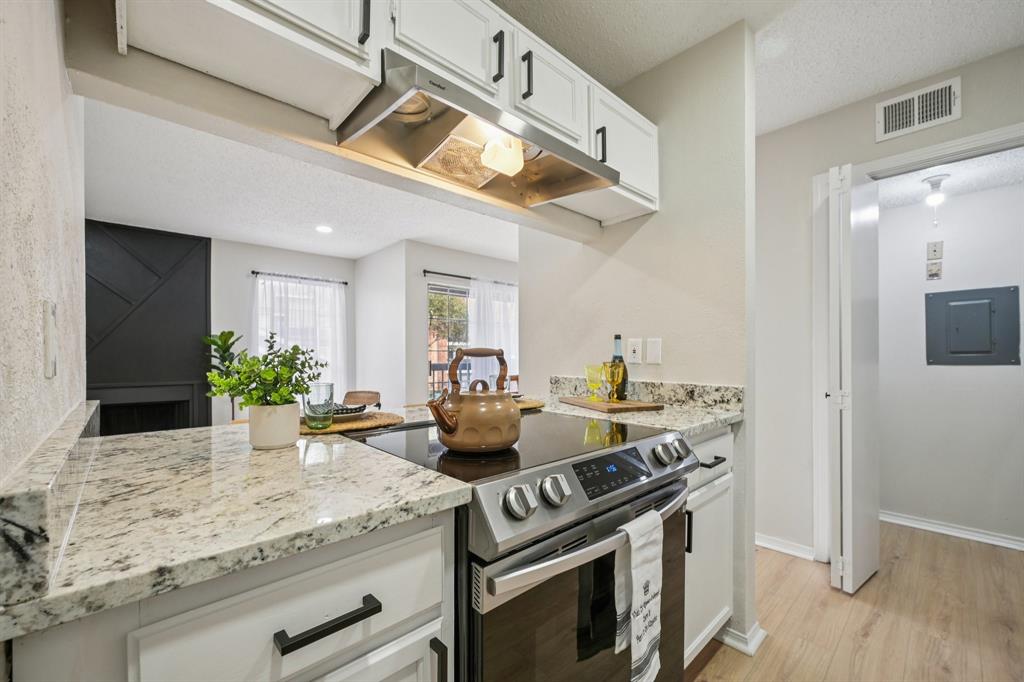 18333 Roehampton Drive, Unit 128 Dallas, TX 75252 - Photo 25 of 40 a kitchen with a stove and a wooden floor