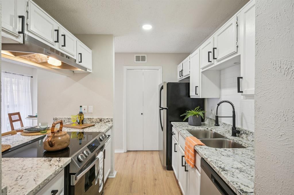 18333 Roehampton Drive, Unit 128 Dallas, TX 75252 - Photo 9 of 40 a kitchen with stainless steel appliances granite countertop a sink stove and refrigerator