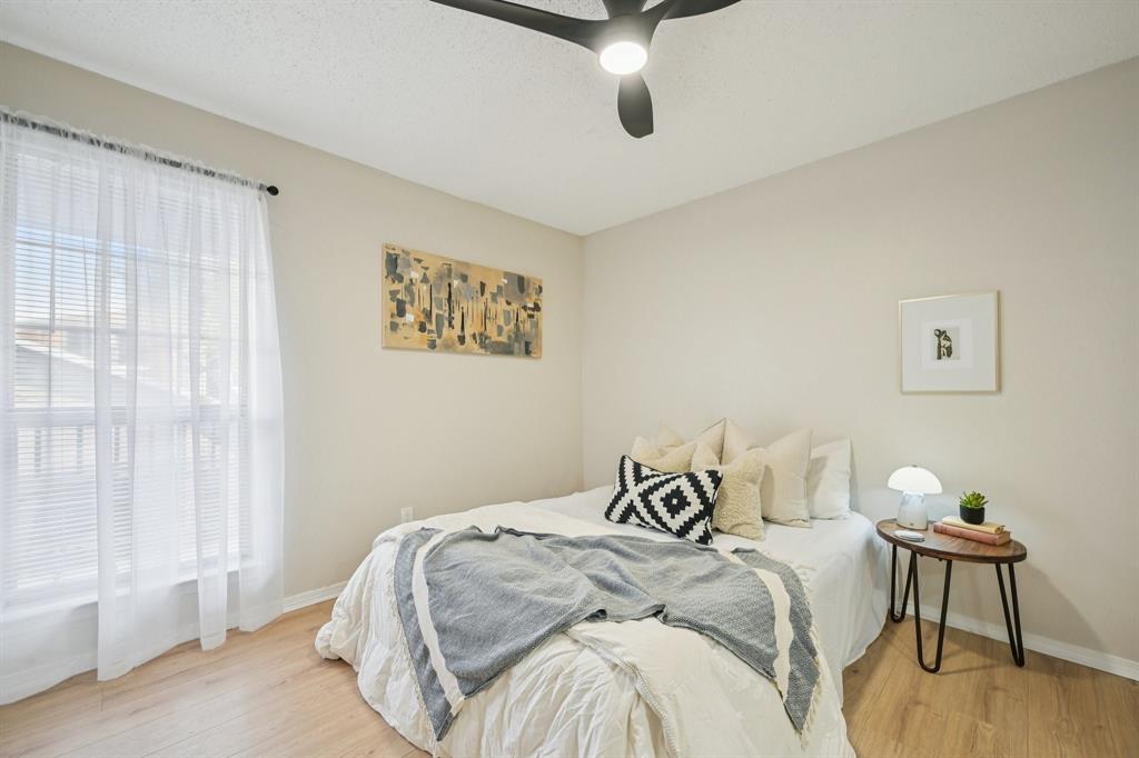18333 Roehampton Drive, Unit 128 Dallas, TX 75252 - Photo 10 of 40 a bedroom with a bed and a chair