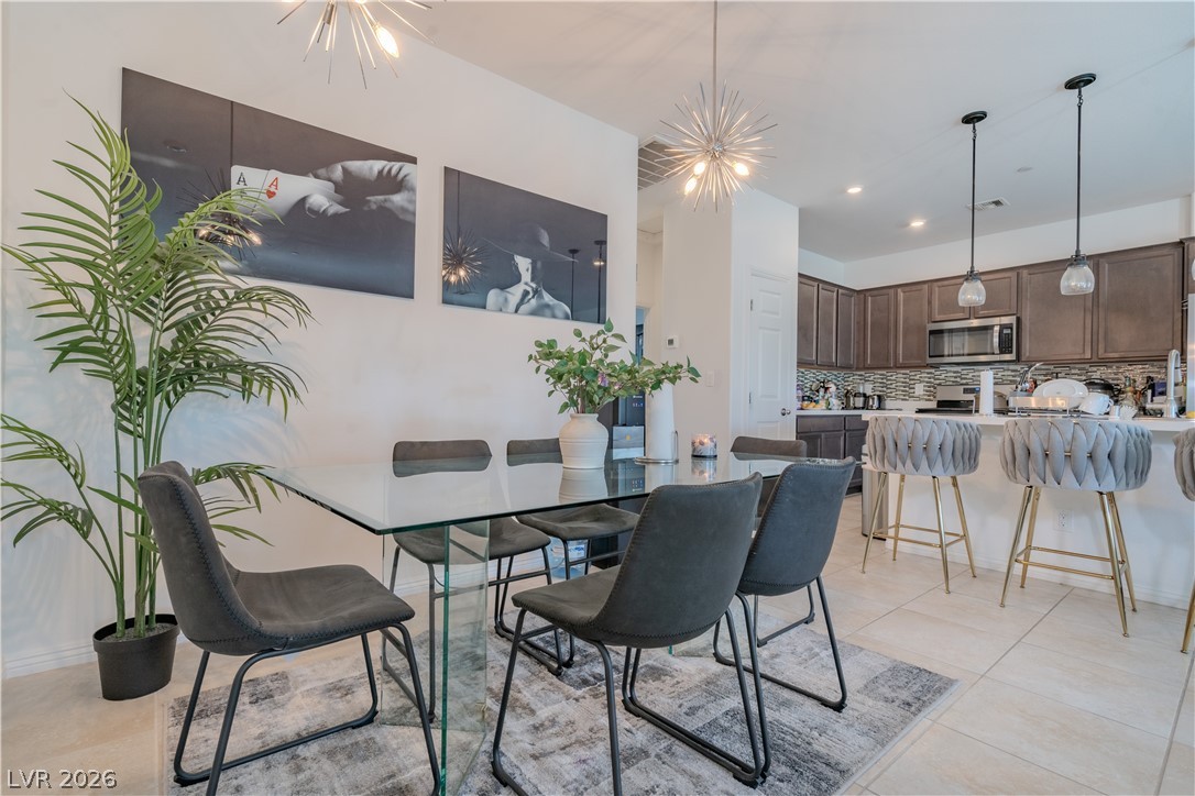 1239 Raritan Place Henderson, NV 89002 - Photo 2 of 26 Dining area with a chandelier and light tile patterned flooring