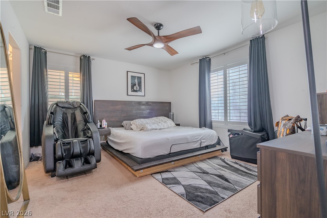 1239 Raritan Place Henderson, NV 89002 - Photo 9 of 26 Primary bedroom downstairs with light colored carpet and ceiling fan