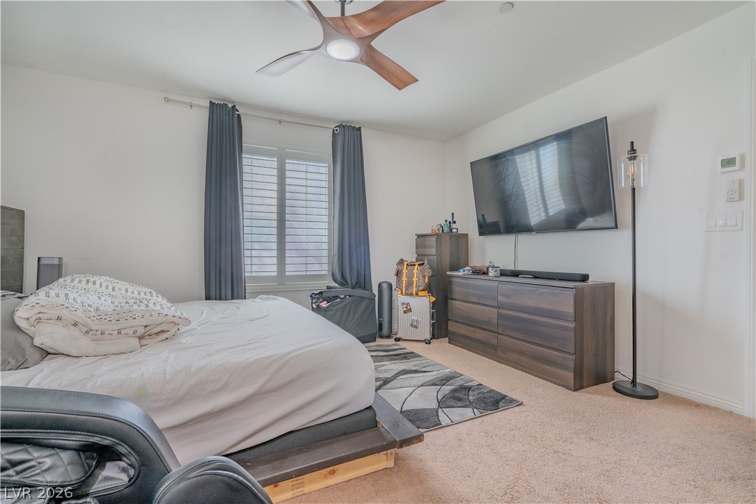 1239 Raritan Place Henderson, NV 89002 - Photo 10 of 26 Primary bedroom downstairswith light carpet and a ceiling fan