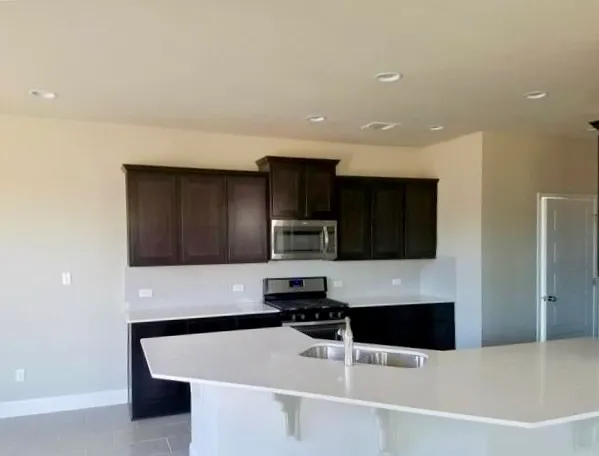 a kitchen with granite countertop a stove and a refrigerator