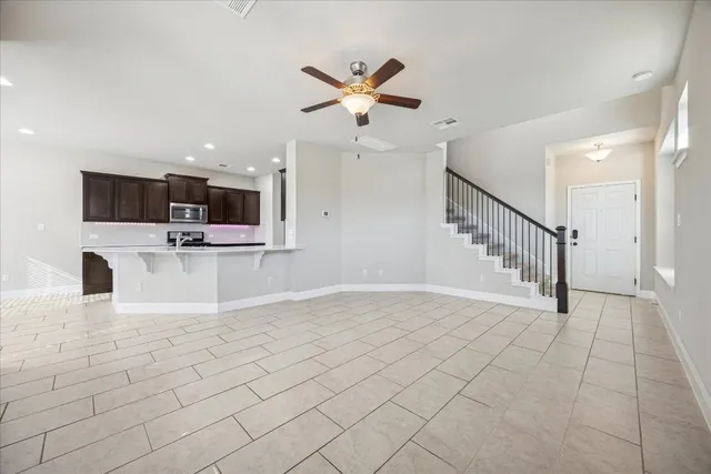 a view of a livingroom with furniture a flat screen tv and ceiling fan