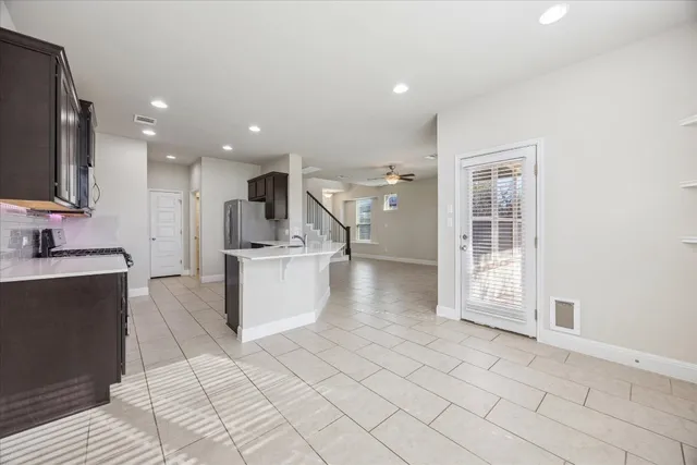 a view of a kitchen with kitchen island granite countertop a sink and a stove top oven
