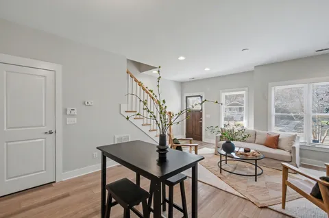 a living room with furniture and a wooden floor