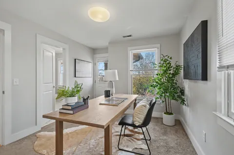 a view of a dining room with furniture and potted plant