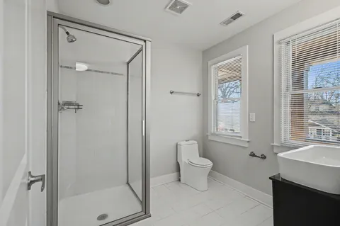 a bathroom with a toilet a sink and shower
