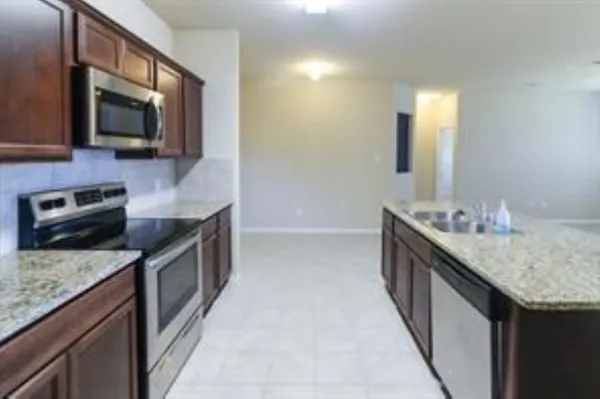 a kitchen with stainless steel appliances granite countertop a sink stove and microwave