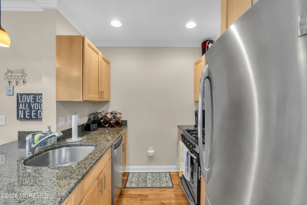 a kitchen with stainless steel appliances granite countertop a sink stove and refrigerator
