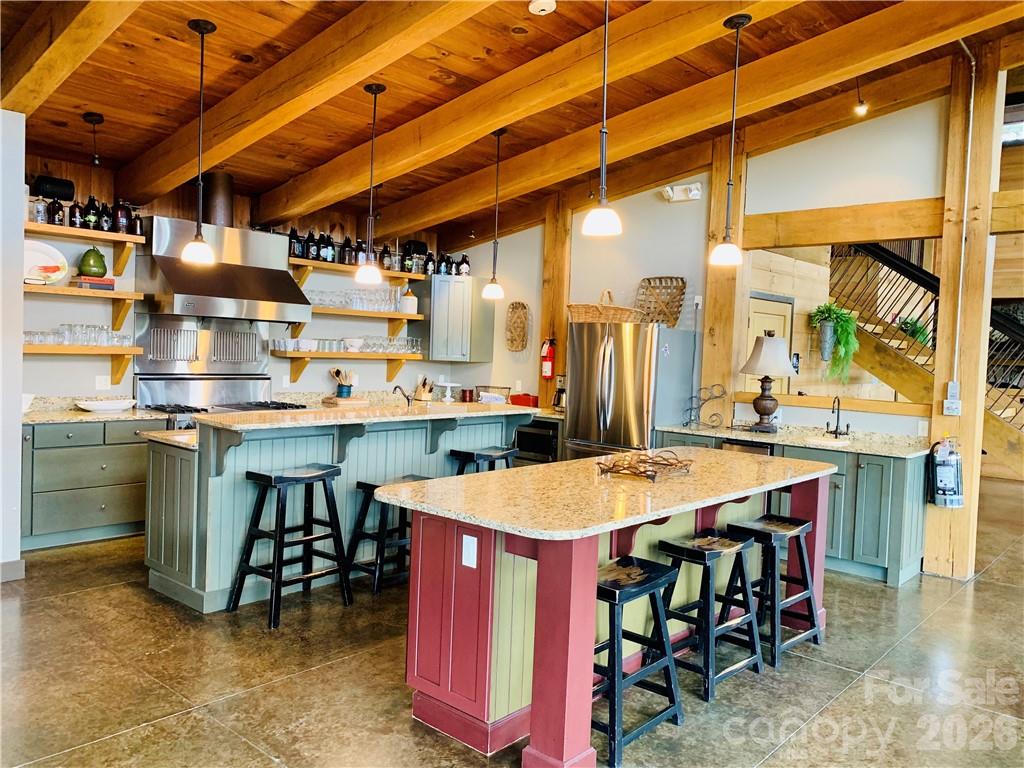 75 Wild Turkey Loop, Unit 31 Marshall, NC 28753 - Photo 13 of 38 a dining hall with stainless steel appliances kitchen island granite countertop a table chairs and a refrigerator