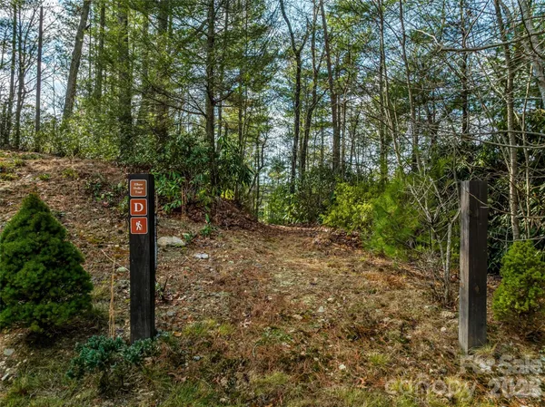 a sign broad in front of the red tree