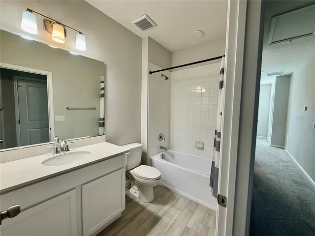 a bathroom with a double vanity sink toilet mirror and shower
