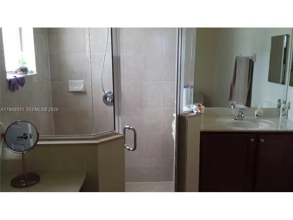 a bathroom with a sink a mirror and shower