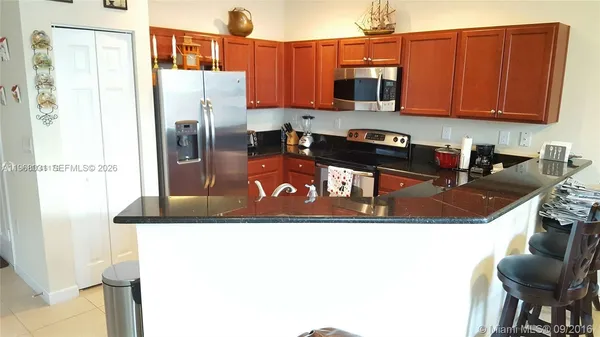 a kitchen with stainless steel appliances granite countertop a refrigerator and a stove top oven