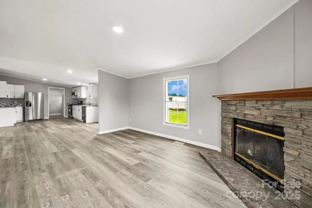 a view of empty room with a fireplace and window