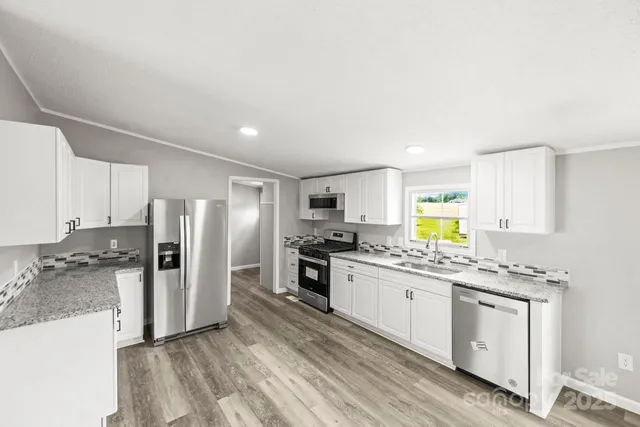 a kitchen with stainless steel appliances a refrigerator sink and stove