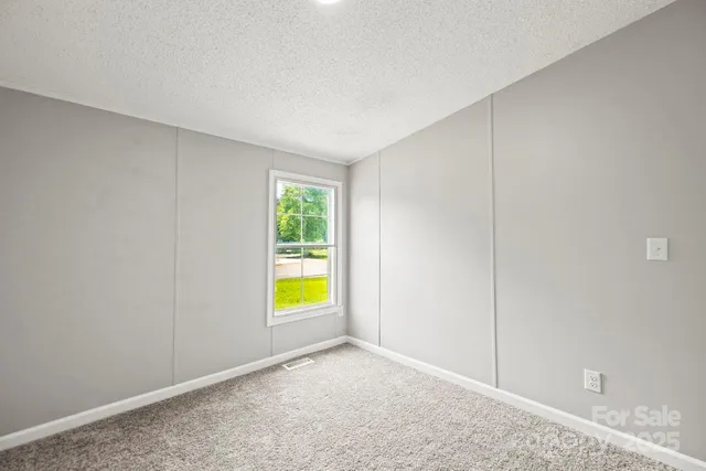 an empty room with a window and swimming pool