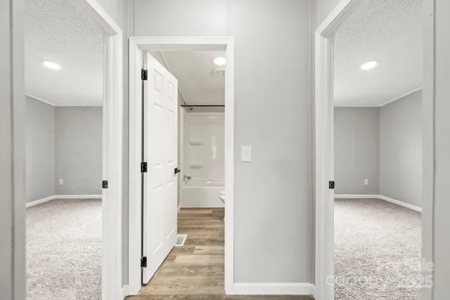 a view of a hallway with wooden floor and staircase