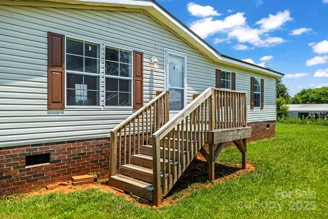 a view of a house with a small deck and a garden
