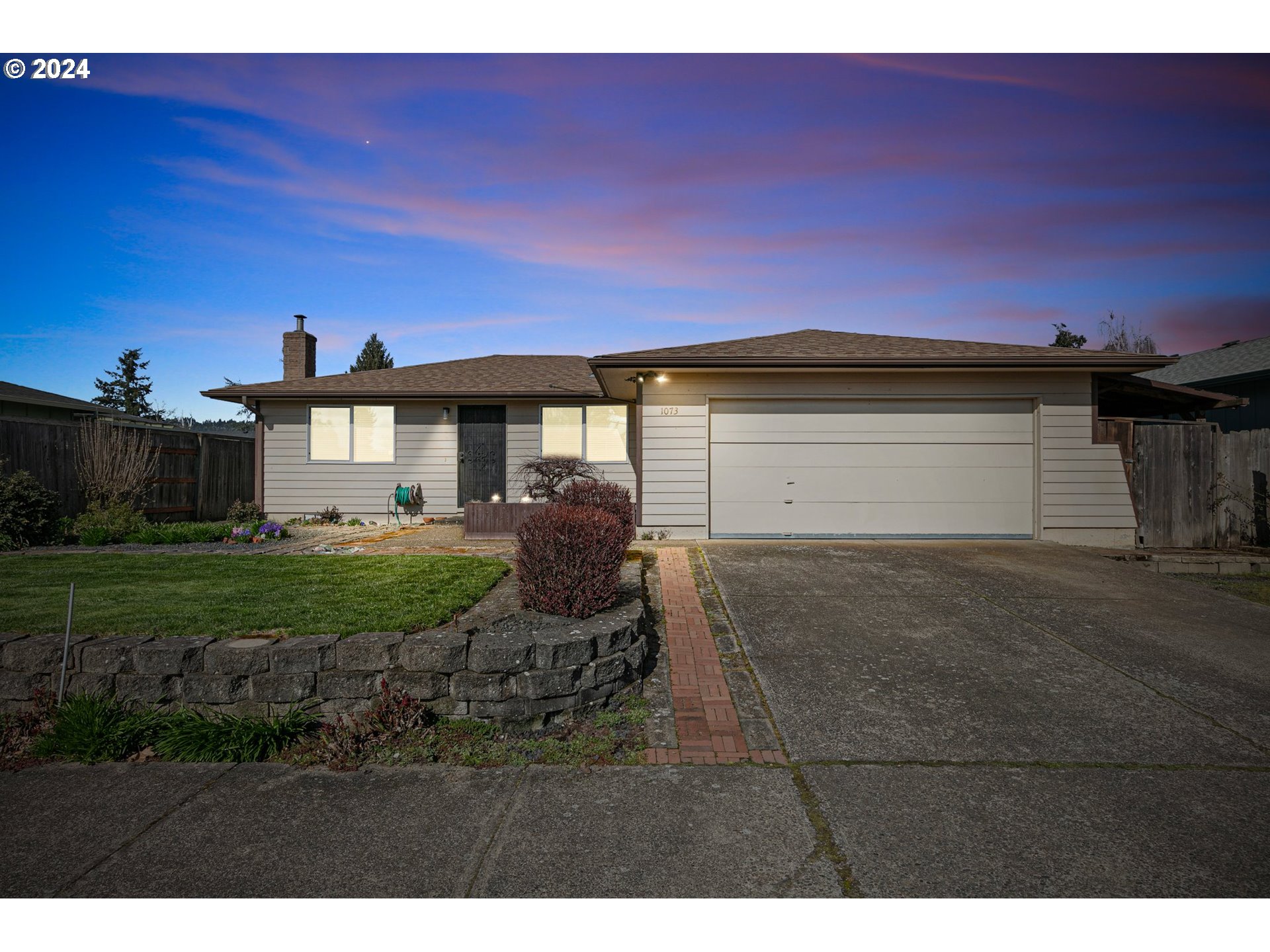 1073 56th Place Springfield, OR 97478 - Photo 1 of 27 a front view of a house with a garden