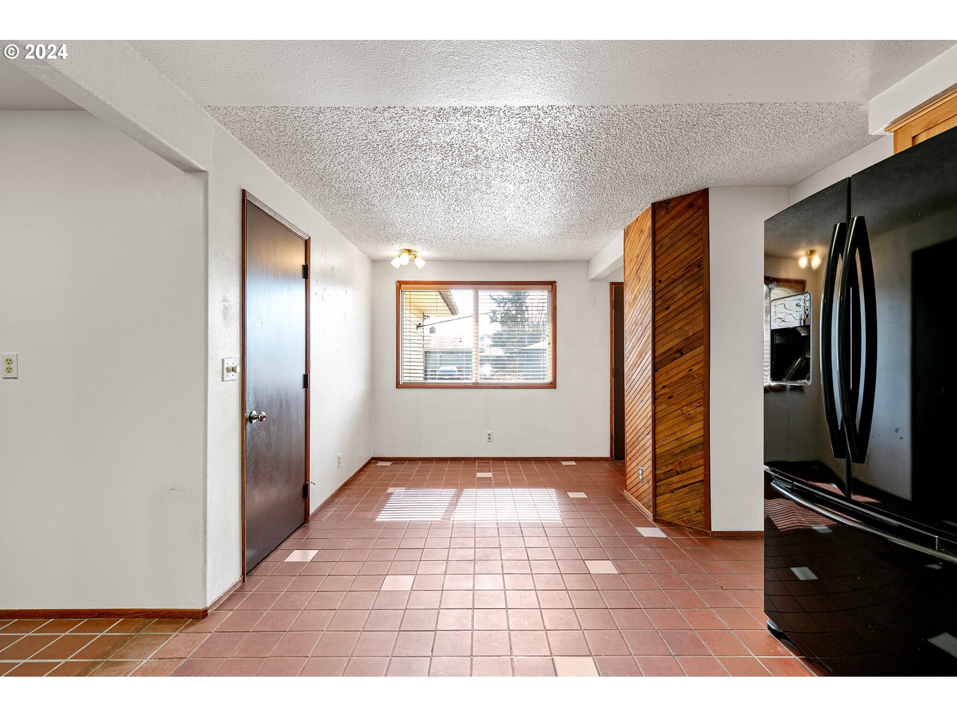 1073 56th Place Springfield, OR 97478 - Photo 7 of 27 a view of a refrigerator in kitchen and an empty room