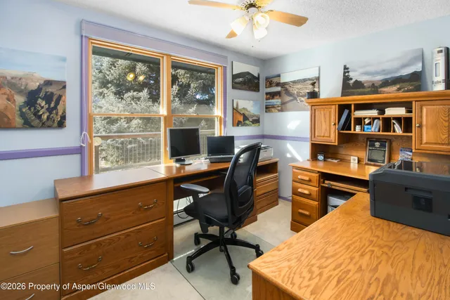 a view of a workspace with furniture and a window