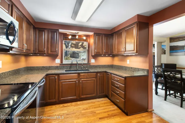 a kitchen with stainless steel appliances granite countertop a stove a sink and a microwave