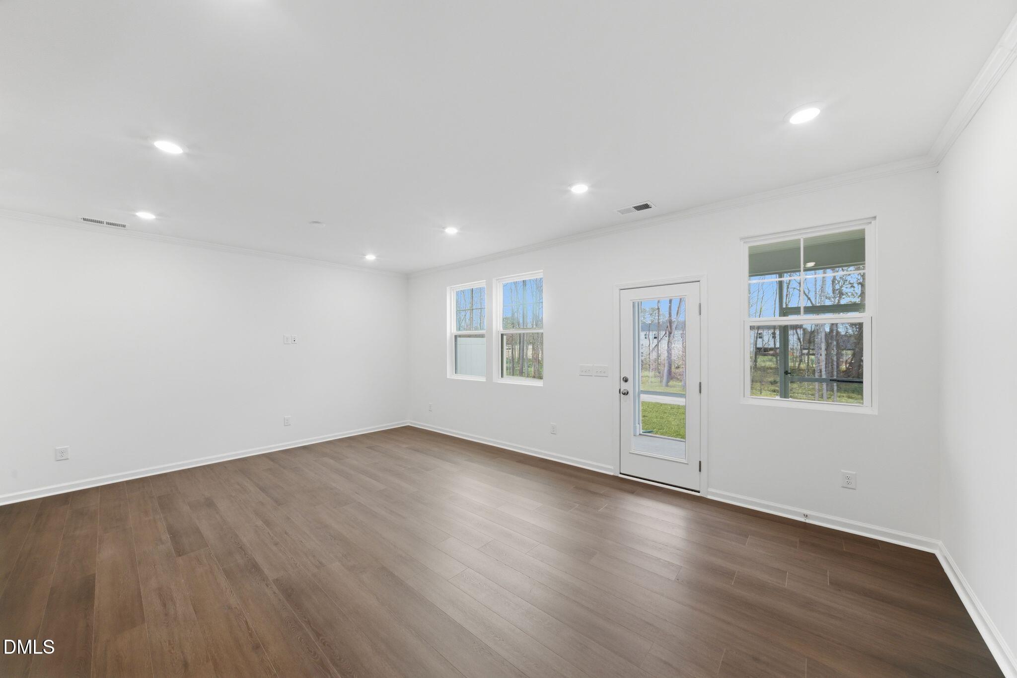 125 Tree Moss Court Rolesville, NC 27571 - Photo 11 of 30 an empty room with wooden floor and windows