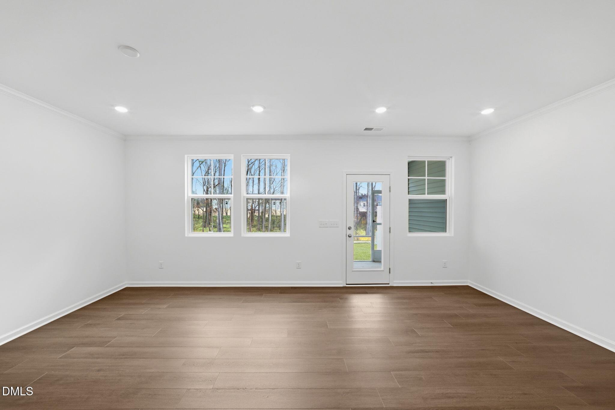125 Tree Moss Court Rolesville, NC 27571 - Photo 12 of 30 an empty room with wooden floor and windows