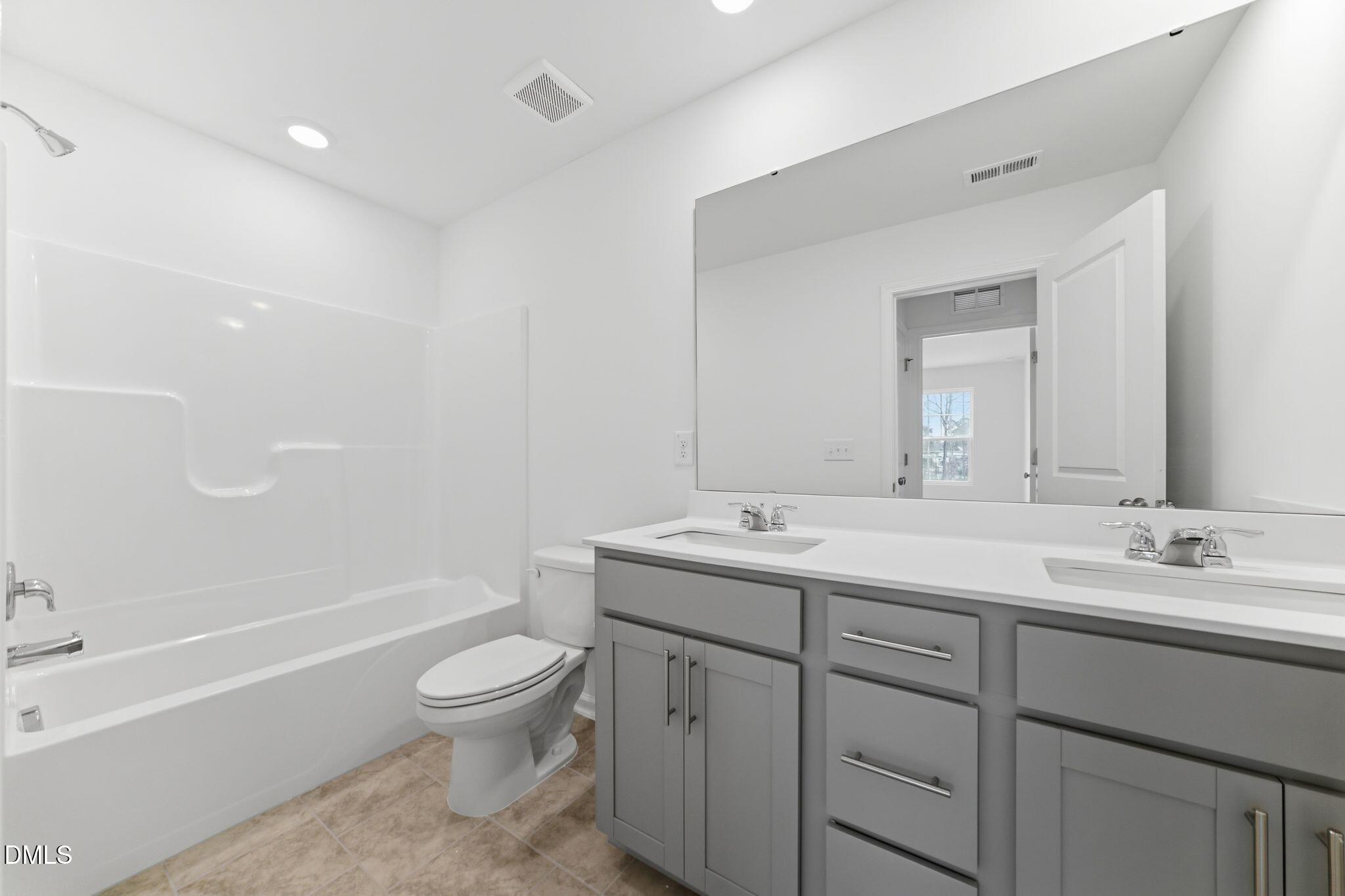 125 Tree Moss Court Rolesville, NC 27571 - Photo 14 of 30 a bathroom with a toilet a sink a mirror a bathtub and vanity