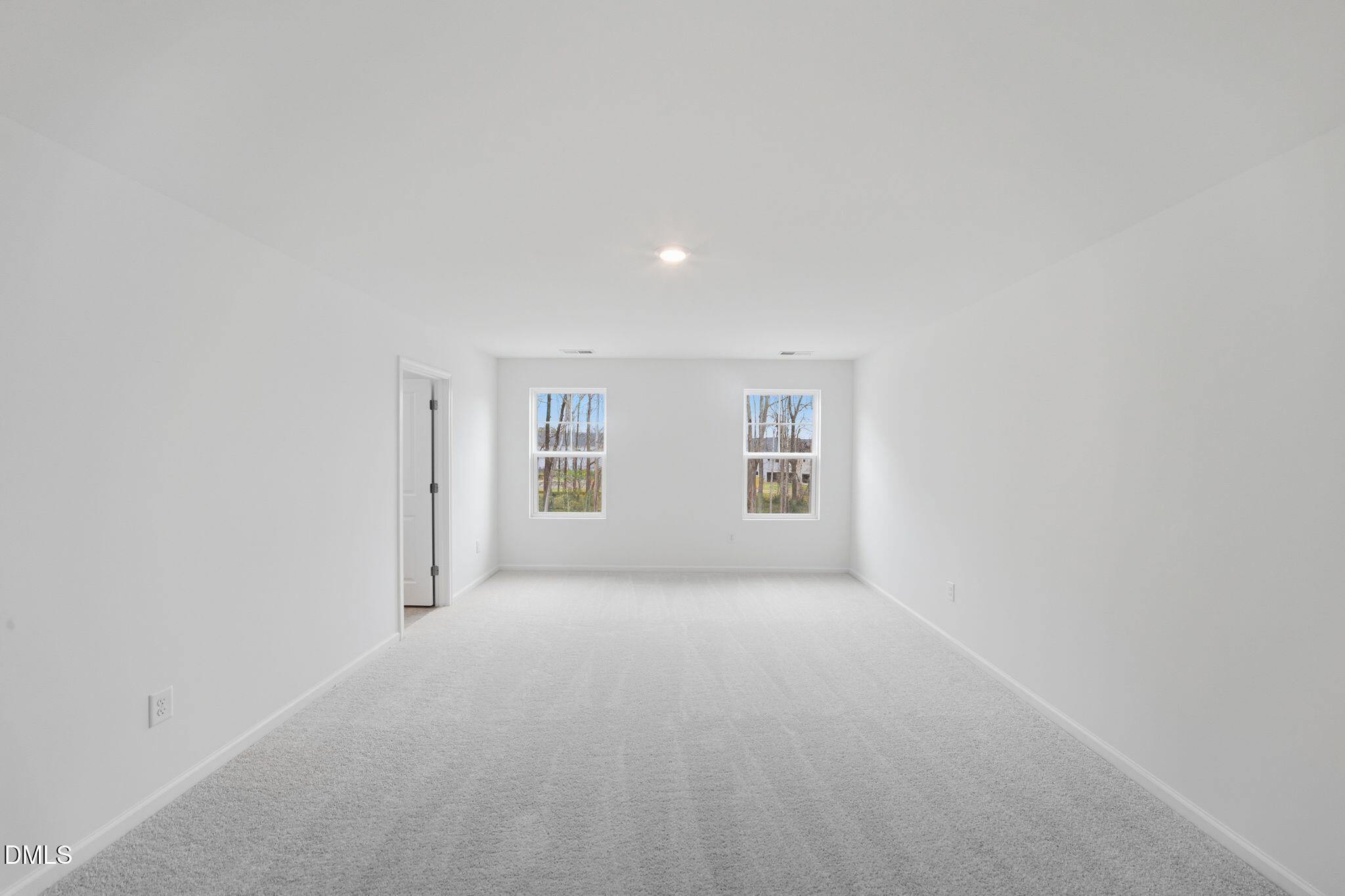 125 Tree Moss Court Rolesville, NC 27571 - Photo 22 of 30 a view of a big room with windows and chandelier fan