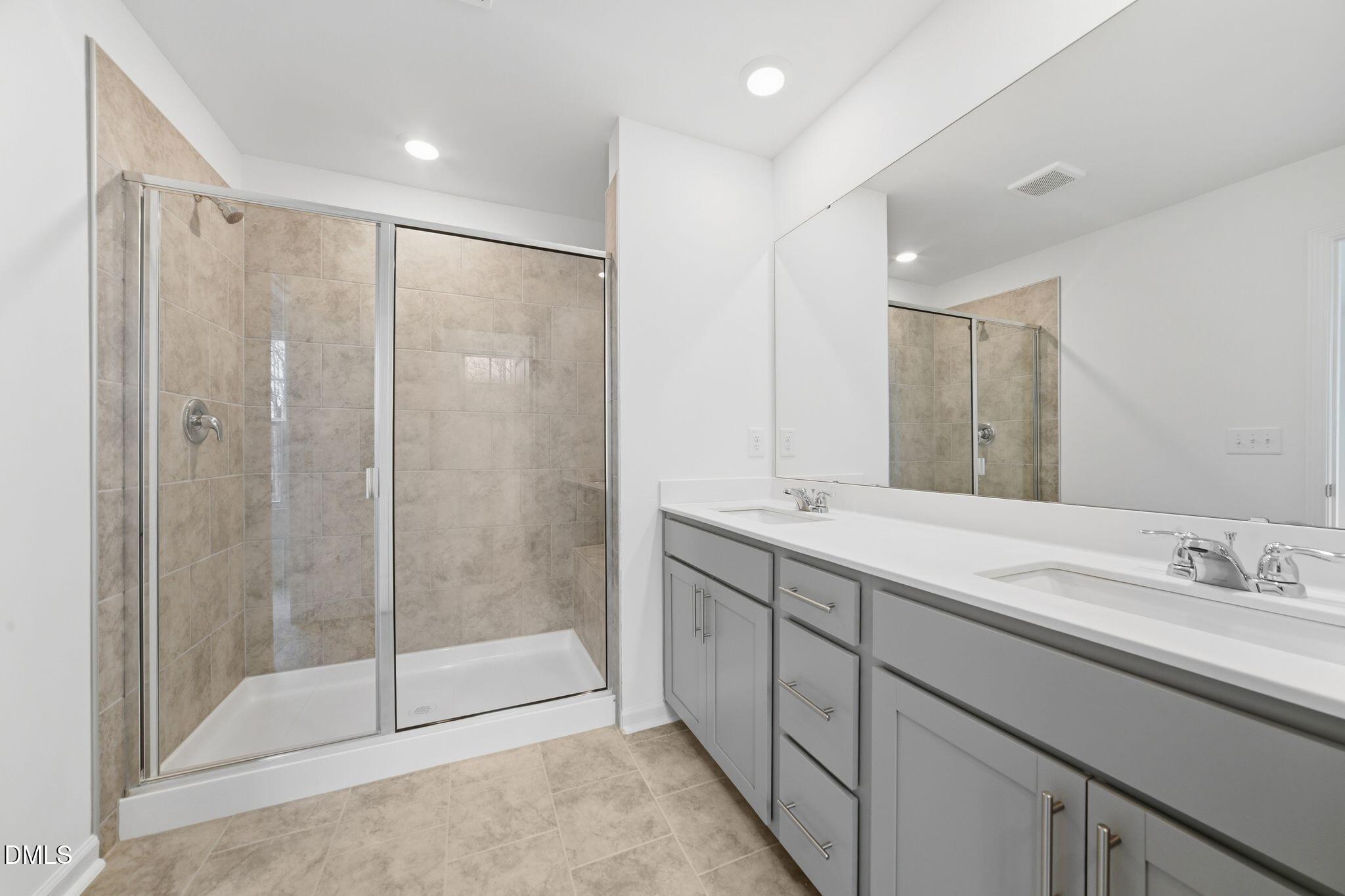 125 Tree Moss Court Rolesville, NC 27571 - Photo 24 of 30 a bathroom with a shower sink and mirror
