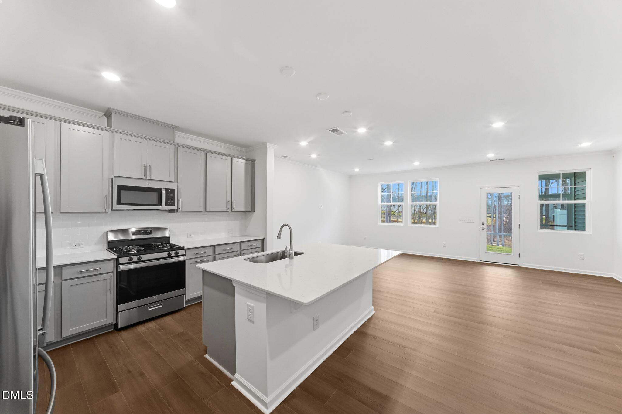 125 Tree Moss Court Rolesville, NC 27571 - Photo 4 of 30 a kitchen with a sink wooden floor and stainless steel appliances