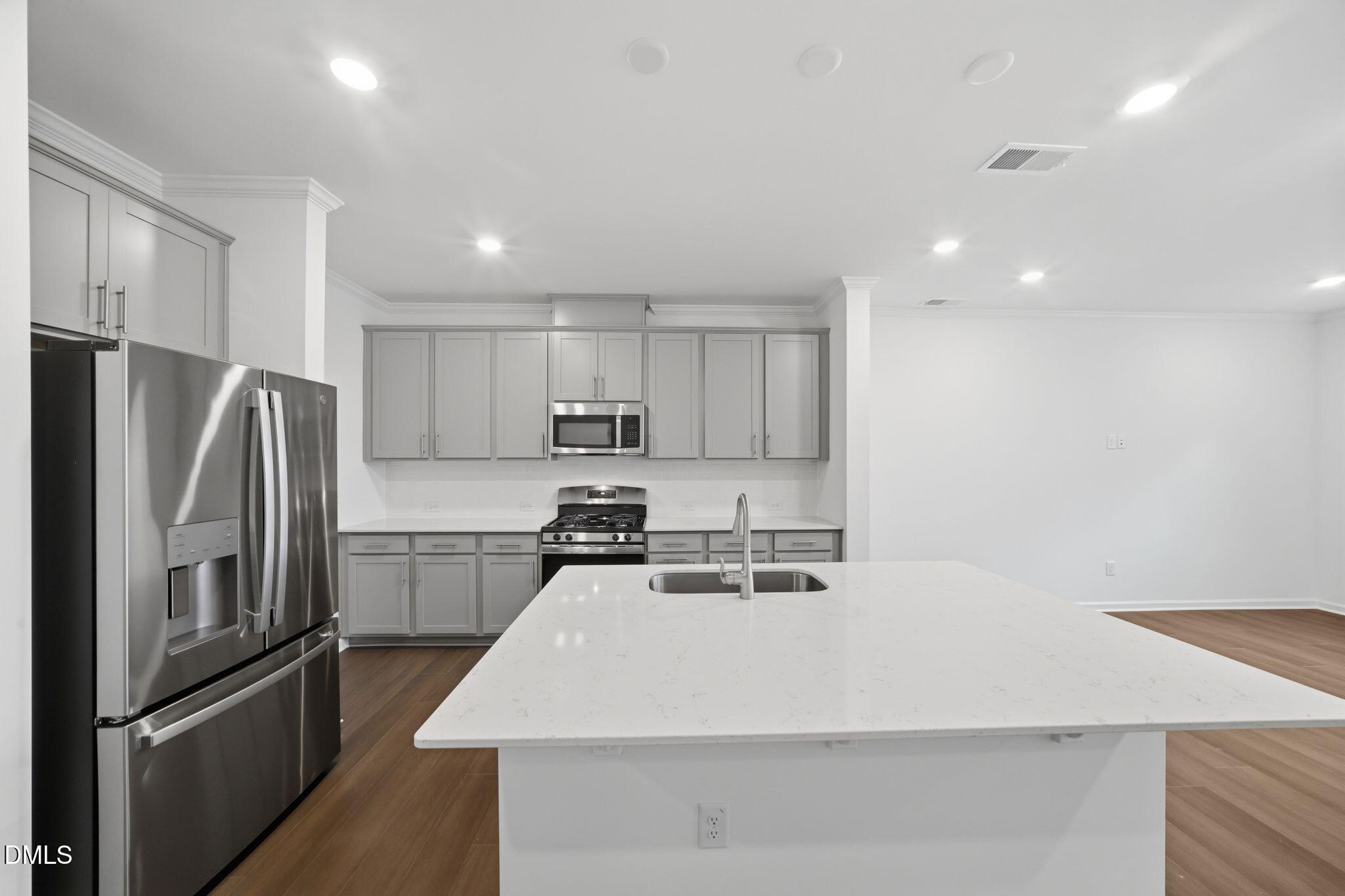 125 Tree Moss Court Rolesville, NC 27571 - Photo 5 of 30 a kitchen with stainless steel appliances a refrigerator stove microwave and cabinets