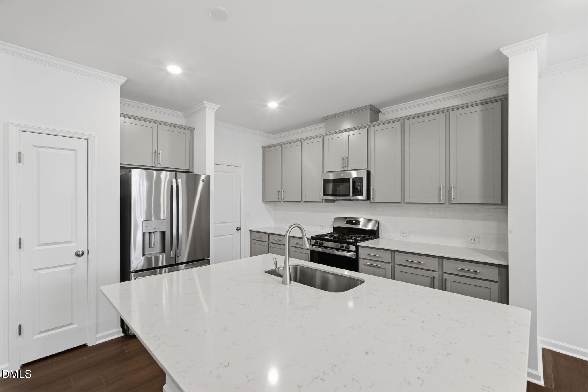 125 Tree Moss Court Rolesville, NC 27571 - Photo 6 of 30 a kitchen with stainless steel appliances granite countertop a refrigerator stove microwave and sink