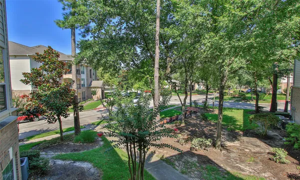 a backyard of a house with lots of green space and fountain