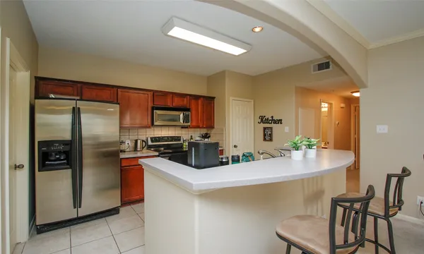 a kitchen with a sink stainless steel appliances and dining table