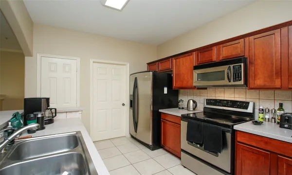 a kitchen with stainless steel appliances granite countertop a refrigerator and a stove top oven