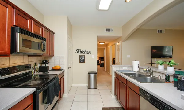 a kitchen with stainless steel appliances a stove sink microwave and cabinets